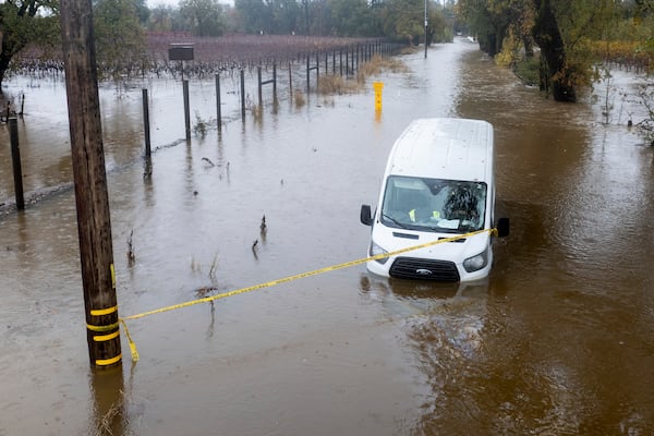 Floodwaters surround a van as heavy rains fall in Windsor, Calif., on Friday, Nov. 22, 2024. (AP Photo/Noah Berger)