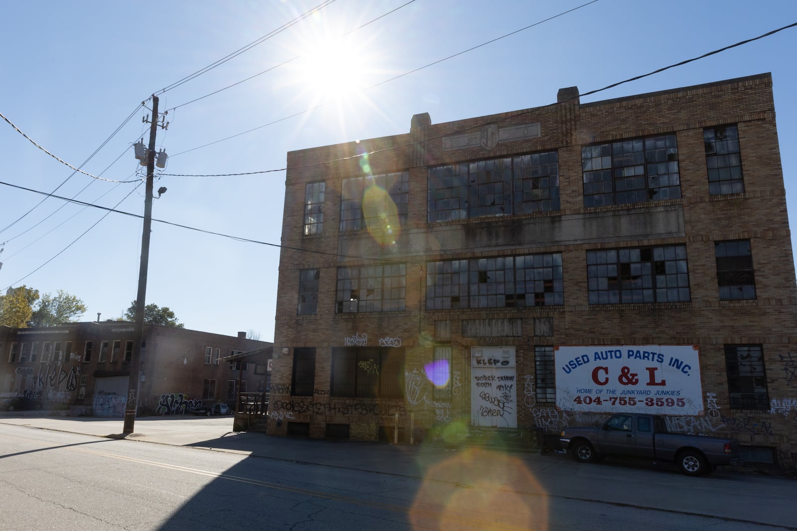 A view of the building that used to be Johnson-Fluker Wholesale Candy Manufacturing Company’s factory in Atlanta on Wednesday, October 16, 2024. The building, which is now part of C&L scrap yard, is part of the Abrams Fixtures adaptive reuse project. (Arvin Temkar / AJC)