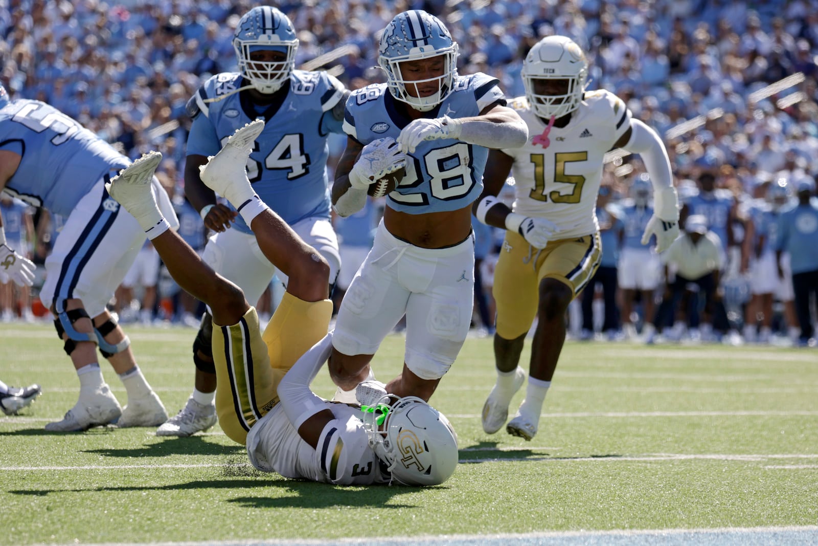 North Carolina running back Omarion Hampton (28) is tackled just short of the goal line by Georgia Tech defensive back Ahmari Harvey, bottom, during the first half of an NCAA college football game, Saturday, Oct. 12, 2024, in Chapel Hill, N.C. (AP Photo/Chris Seward)