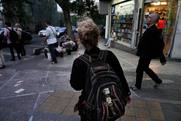 FILE - An Iranian woman, without a mandatory headscarf, or hijab, walks in downtown Tehran, Iran, June 10, 2024. (AP Photo/Vahid Salemi, File)