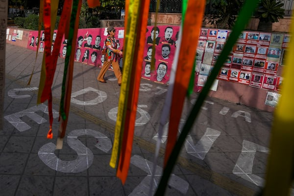 A pedestrian walks over a sign that reads in Spanish, "Where are they?" referencing missing people, at Obregon square in Culiacan, Sinaloa state, Mexico, Thursday, Feb. 27, 2025. (AP Photo/Fernando Llano)