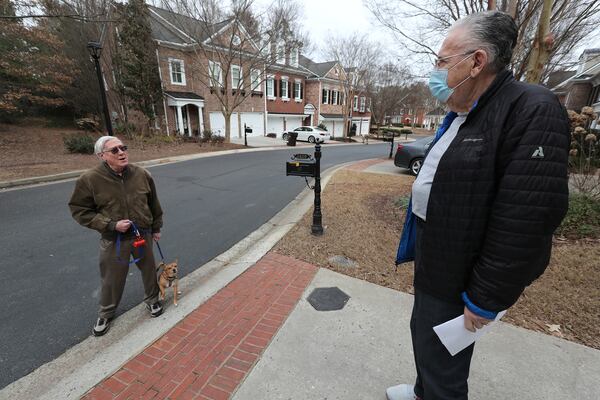 Ron Kurtz (right), who is having difficulty getting a second COVID-19 vaccination, discusses the problem with his neighbor, Ian Bamber, who said he is experiencing the same issues. (Curtis Compton / Curtis.Compton@ajc.com)