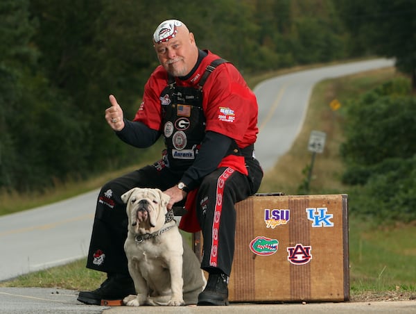 Mike "Big Dawg" Woods from Colbert and his English Bulldog, Munson. Wood's wife, Dianne, has been painting his head for UGA football games since 1991. It's a tradition Woods picked up from his father, Lonnie Woods.  His dad, a UGA bus driver, started the tradition at the encouragement of the 1980 defensive players that he drove to games. After his death, Mike took over the tradition. (Brant Sanderlin/AJC file photo)