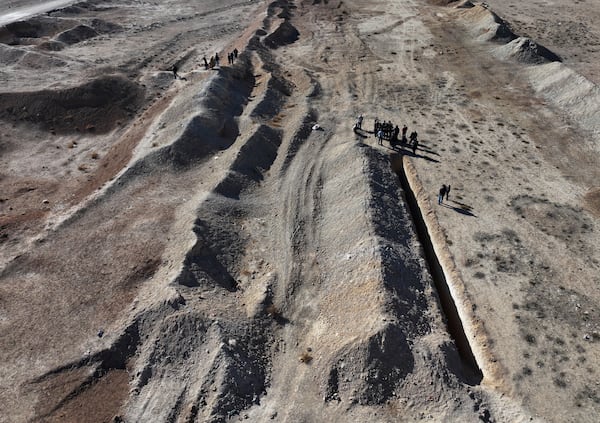 Activists from The U.S.-based Syrian Emergency Task Force and people observe a location identified as a mass grave for detainees killed under rule of Bashar Assad in Najha, south of Damascus, Syria, Tuesday, Dec. 17, 2024. (AP Photo/Hussein Malla)