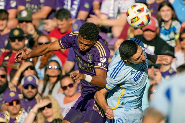 Orlando City's Rafael Santos, left, and Atlanta United's Bartosz Slisz, right, battle for a head ball during the first half of an MLS Semifinal Conference playoff soccer match, Sunday, Nov. 24, 2024, in Orlando, Fla. (AP Photo/John Raoux)