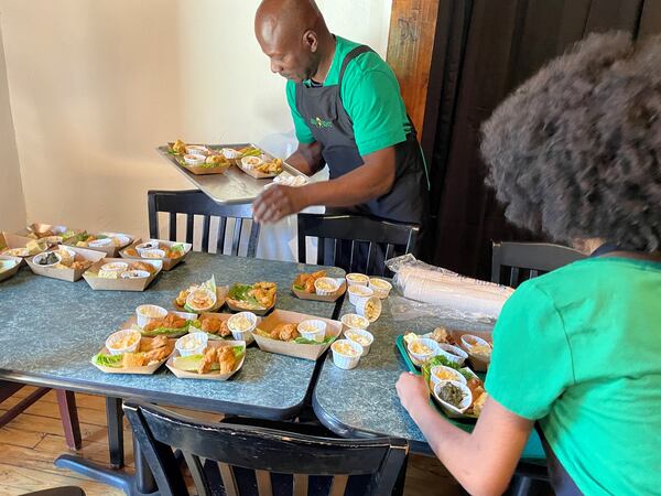 Servers prepare sample dishes Monday during the formal opening of The Green Front Cafe in Stockbridge.