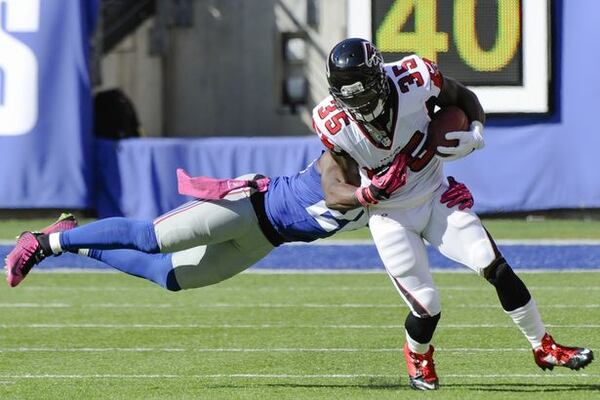 Atlanta Falcons running back Antone Smith, right, avoids the tackle of New York Giants strong safety Antrel Rolle during a scoring on a touchdown reception during the second half of an NFL football game, Sunday, Oct. 5, 2014, in East Rutherford, N.J. (AP Photo/Bill Kostroun)