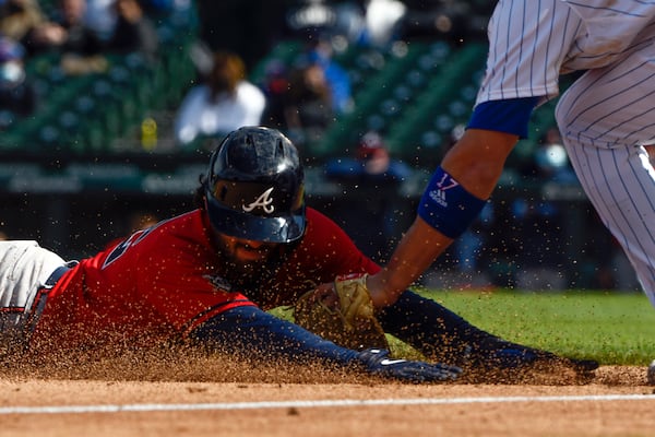 Dansby Swanson of the Braves is tagged at third base by Chicago Cubs third baseman Kris Bryant during the fifth inning  Friday, April 16, 2021, in Chicago. (AP Photo/Matt Marton)