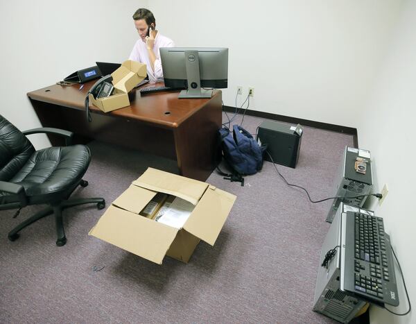 Ky Parker, System Administrator for InterDev, contracted by South Fulton, sets up new phones. Monday was the first day of work for former Fulton County employees who are now working for the city of South Fulton. BOB ANDRES /BANDRES@AJC.COM