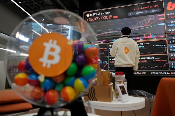 An employee watches an electronic signboard displaying the prices of Bitcoin and other cryptocurrencies at the lounge of Bithumb cryptocurrency exchange in Seoul, South Korea, Thursday, Nov. 21, 2024. (AP Photo/Ahn Young-joon)