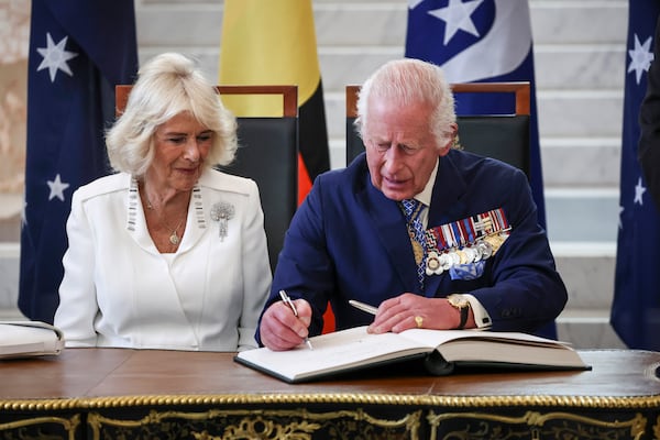 Britain's King Charles III and Queen Camilla sign a visitors' book in the Marble Foyer of Parliament House in Canberra, Australia, Monday, Oct. 21, 2024. (David Gray/Pool Photo via AP)