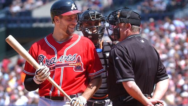 Braves pitcher John Smoltz shares a light moment with the umpire before batting against the New York Mets Sunday, April 10, 2005, at Turner Field. (Charlotte B. Teagle/AJC)