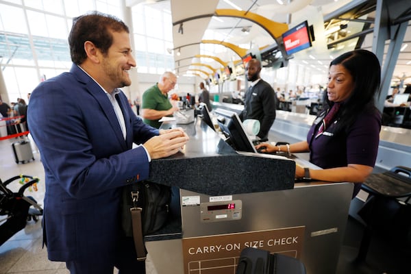 A Delta Air Lines agent at Hartsfield-Jackson International Airport greets business traveler Eric Goldmann on Wednesday, September 21, 2022. Thousands of frequent business travelers who live in metro Atlanta are a fundamental part of the region's economy. Wednesday, September 21, 2022. Miguel Martinez / miguel.martinezjimenez@ajc.com 