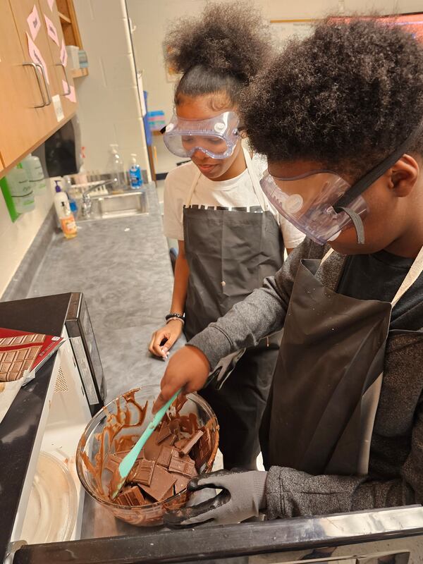 Eighth graders at Mason Creek Middle work on various methods of melting chocolate to learn about heat transference. Courtesy