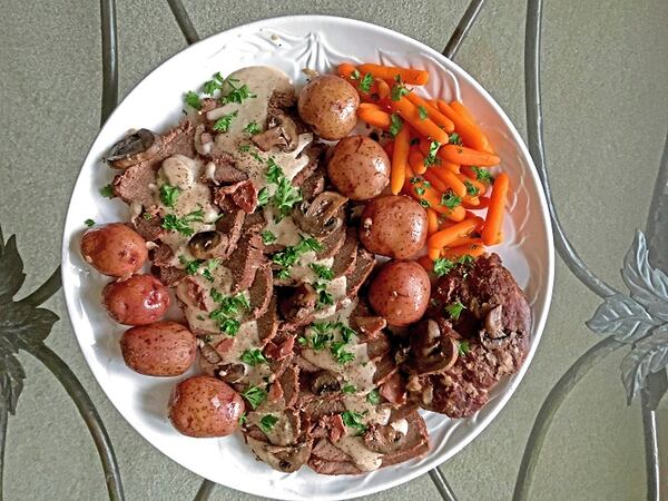 Venison with mushrooms in a sour cream gravy, plated with new potatoes and carrots. (Karen Kane/Post-Gazette)