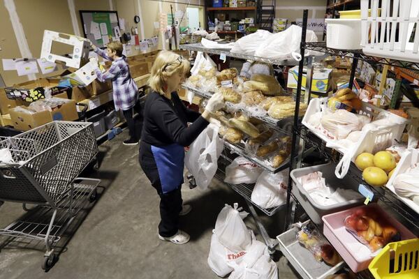 Workers select items to be given to a family at GraceWorks Ministries food pantry in Franklin, Tenn. In addition to finding ways to meet the spike in demand, food banks have had to devise creative new ways to distribute ever greater amounts of food while keeping both recipients and their staff safe from exposure to the coronavirus.