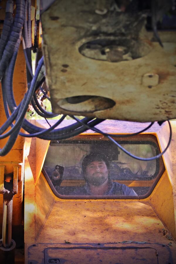 Cason Anderson peers through the windshield of the pecan shaker. (Eric Dusenbery for The Atlanta Journal-Constitution)