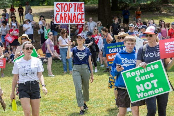 People hold up signs at a rally organized by Georgia Moms Demand Action in Piedmont Park Saturday, May 13, 2023. The rally was part of a national series of protests the day before Mother’s Day to highlight the mounting toll of gun violence.  (Steve Schaefer/steve.schaefer@ajc.com)