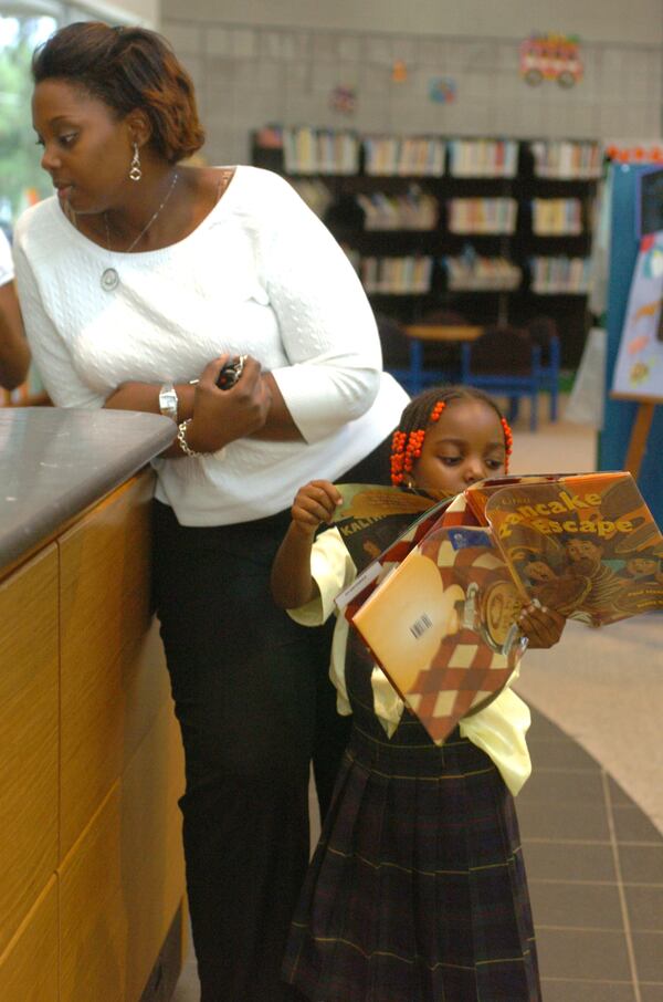  Monique Vassall and her daughter Aniyah Vassall, 4, check out books for Aniyah at the Salem-Panola Branch of the DeKalb County Library system in this AJC file photo.