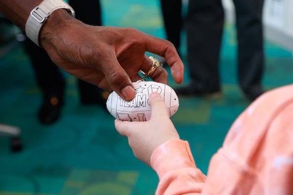 NFL Hall of Famer and former Georgia Tech player Calvin Johnson hands a signed football to Colton Hall, 9, during a visit to Egleston Children’s Hospital in Atlanta on Friday, September 1, 2023. (Natrice Miller/ Natrice.miller@ajc.com) 