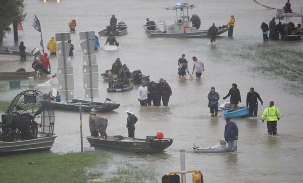 People in Houston walk down a flooded street as they evacuate their homes Monday. (Joe Raedle / Getty Images)