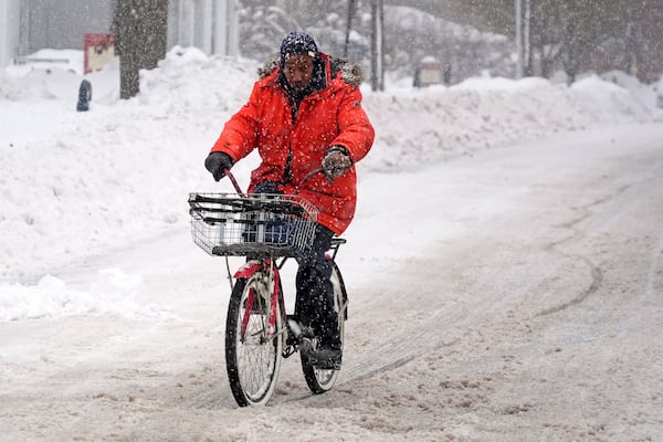 Terrence Yarbrough of Erie, Pa, rides his bicycle through the streets of downtown Erie, Pa, Monday, Dec. 2, 2024. (AP Photo/Gene J. Puskar)