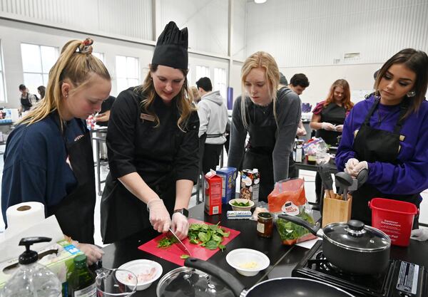 Assistant Principal Whittney McPherson (second from left) demonstrates cooking skills during the second annual Senior Adulting Day at Lumpkin County High School in Dahlonega on Friday, Jan. 24, 2020. 