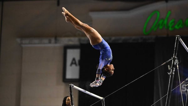 A Fisk University gymnast performs on the bars during a recent competition. Fisk earlier this year became the first historically Black university to field a gymnastics team. Photo credit: Fisk University.