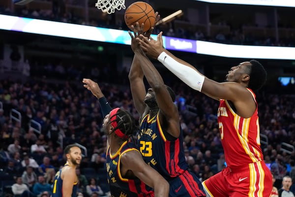 Golden State Warriors forward Draymond Green (23) and Atlanta Hawks forward Onyeka Okongwu, right, compete for possession of the ball during the first half of an NBA basketball game Wednesday, Nov. 20, 2024, in San Francisco. (AP Photo/Godofredo A. Vásquez)