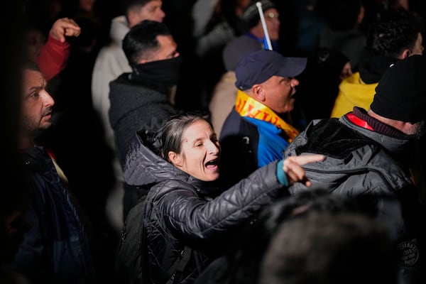 Supporters of Calin Georgescu react during a protest after Romania's electoral body rejected his candidacy in the presidential election rerun in Bucharest, Romania, Sunday, March 9, 2025. (AP Photo/Andreea Alexandru)