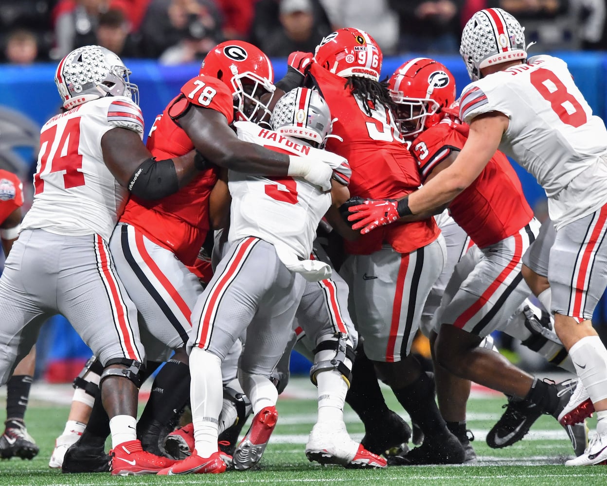 Georgia defenders including Nazir Stackhouse (78) and Zion Logue (96) stop Ohio State Buckeyes running back Dallan Hayden (5). (Hyosub Shin / Hyosub.Shin@ajc.com)