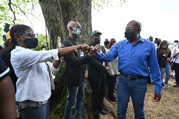 U.S. Sen. Raphael Warnock fist-bumps supporters as he arrives at Jibb's Vineyard in Byromville, where he told Black farmers that "help is on the way." (Hyosub Shin / Hyosub.Shin@ajc.com)