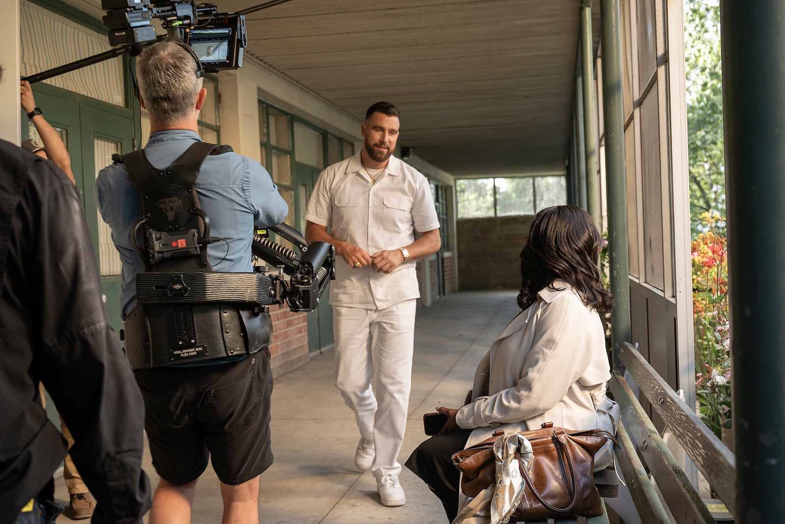 This image released by FX shows Travis Kelce, center, and Niecy Nash, right, during the filming of the series "Grotesquerie." (Prashant Gupta/FX via AP)