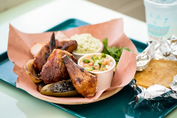 Little Rey Pollo "Al Carbon" served family style with corn tortillas, smoked onions and jalapenos, ranch beans, and cilantro rice. Photo credit- Mia Yakel.