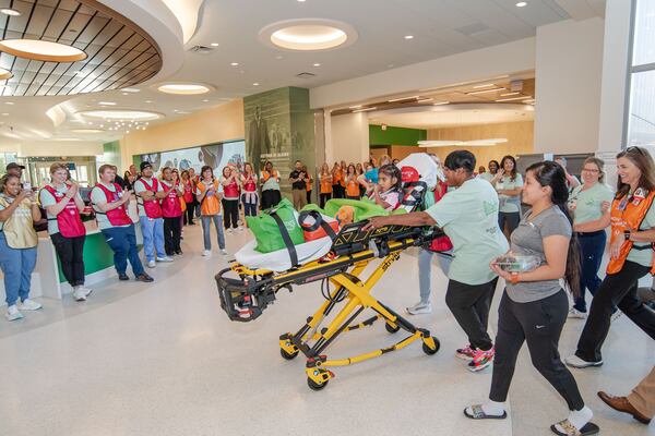 Eight-year-old Brithany Morales arrives to hospital workers' applause as the first-ever patient transferred to the brand-new Arthur M. Blank Hospital. Morales was the first patient to leave Egleston Hospital as it closed for good on Sunday, Sept. 29, 2024, to be transferred to the brand-new Arthur M. Blank Hospital at I-85 and North Druid Hills Road.  Children's Healthcare of Atlanta hopes to move the entire Egleston patient population, hundreds of children, in one day, in ambulances one by one. (Photo courtesy of Children’s Healthcare of Atlanta)