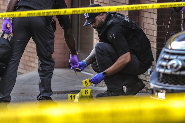 Atlanta police collect shell casings from the scene of a double shooting that left one man dead last month. Atlanta police have investigated 63 homicide cases in 2021, a 58% increase over this time last year. 
