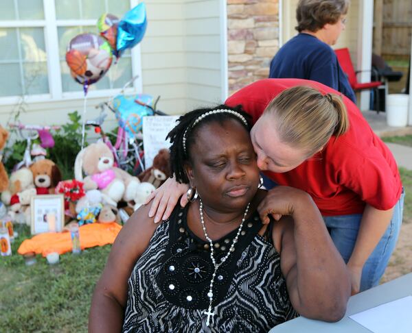 Alice Stout-Osorio, center,grandmother of murdered 13-year-old Nizzear Rodriguez, is comforted by coworker Alaina Stephens in front of her Carrollton home Thursday evening August 28, 2014. BEN GRAY / BGRAY@AJC.COM