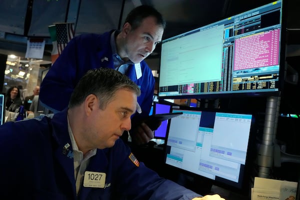 A pair of traders work on the floor of the New York Stock Exchange, Wednesday, March 12, 2025. (AP Photo/Richard Drew)