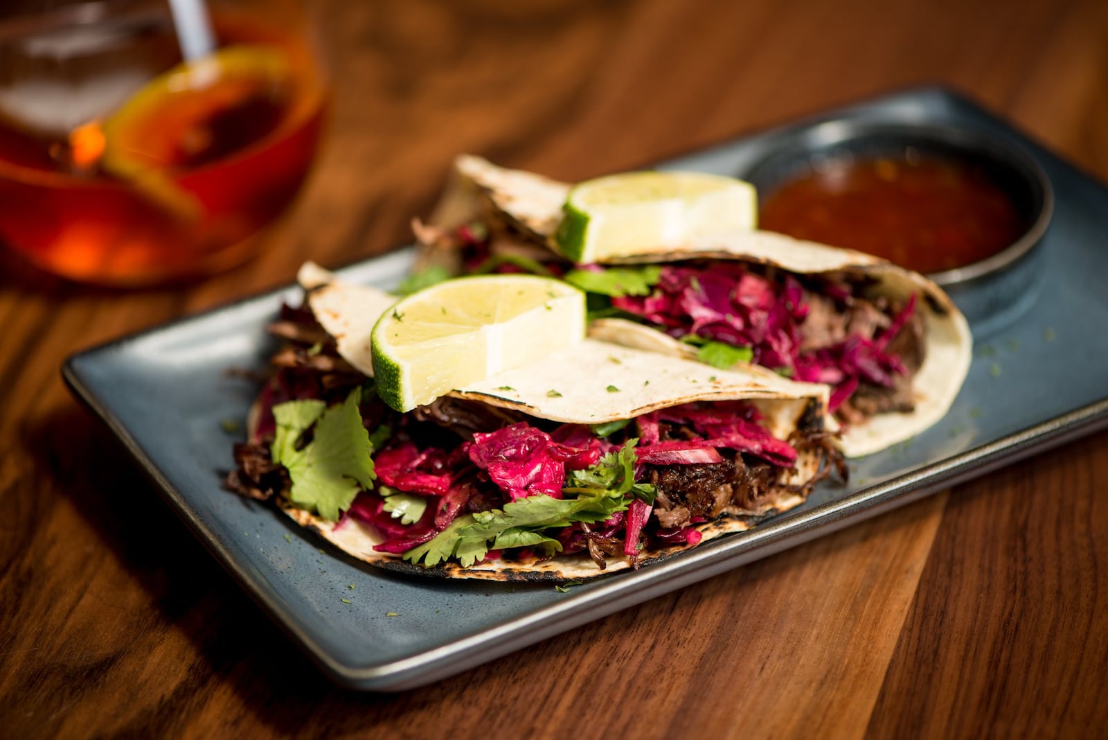 Beef Barbacoa Tacos, shredded beef tacos garnished with sweet pickled onions and fresh cilantro. Photo credit- Mia Yakel.