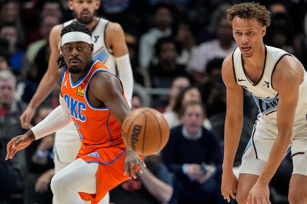 Oklahoma City Thunder guard Luguentz Dort (5) and Oklahoma City Thunder guard Luguentz Dort (5) vie for a loose ball during the first half of an NBA basketball game, Friday, Feb. 28, 2025, in Atlanta. (AP Photo/Mike Stewart)