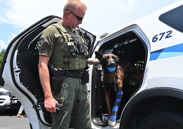 June 14, 2022 Buford - Cpl. Aaron Carlyle pets K-9 Kai, who was shot multiple times during an aggravated domestic incidents, after releasing from North Georgia Veterinary Specialists in Buford on Tuesday, June 14, 2022. Kai is a 2-year-old Belgian Malinois that performs dual roles as a patrol and narcotics. The dog has worked with Gwinnett police for less than a year. (Hyosub Shin / Hyosub.Shin@ajc.com)