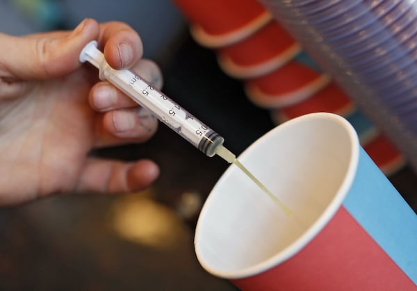 A barista uses a syringe to measure a 10 milliliter shot added to a black coffee at Rev Coffee in Smyrna. Cannabidiol oil products are gaining in popularity. Bob Andres / bandres@ajc.com