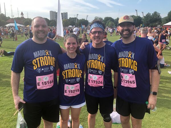 Nick Kelly, Lauren Izzo, Chris Buechner and Eric Kelly wear "Maddox Strong" T-shirts during the AJC Peachtree Road Race. Nick's son, Maddox, is battling leukemia, a cancer that attacks blood-forming tissues and cells.