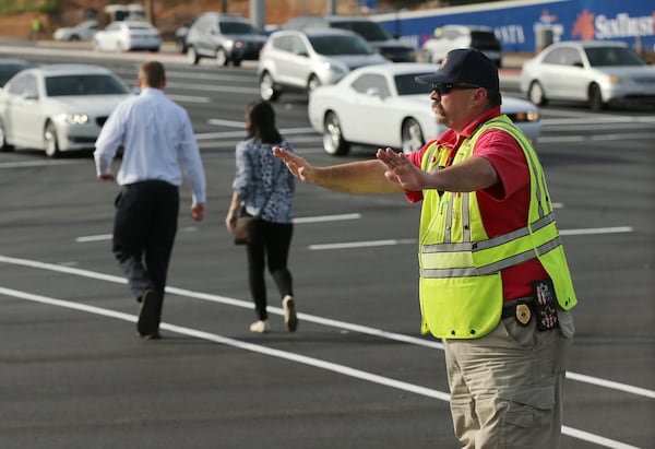 Cobb has started recruiting firefighters on overtime to work some of the pedestrian crossings outside the development. A Cobb Fire Department employee works pedestrian control at the intersection of Spring Road and Circle 75 Parkway outside the SunTrust Park development during the Braves game on Wednesday, May 3, 2017, in Atlanta. CURTIS COMPTON/CCOMPTON@AJC.COM