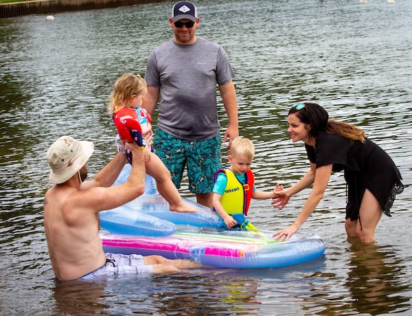 Tommy Oswald his daughter Emery Oswald, 2, Phillip Godfrey (C) Winston Godfrey, 3 and Kelli Oswald cool off in Lake Lanier at Mary Alice Park on Lake Lanier in Cumming. STEVE SCHAEFER / SPECIAL TO THE AJC