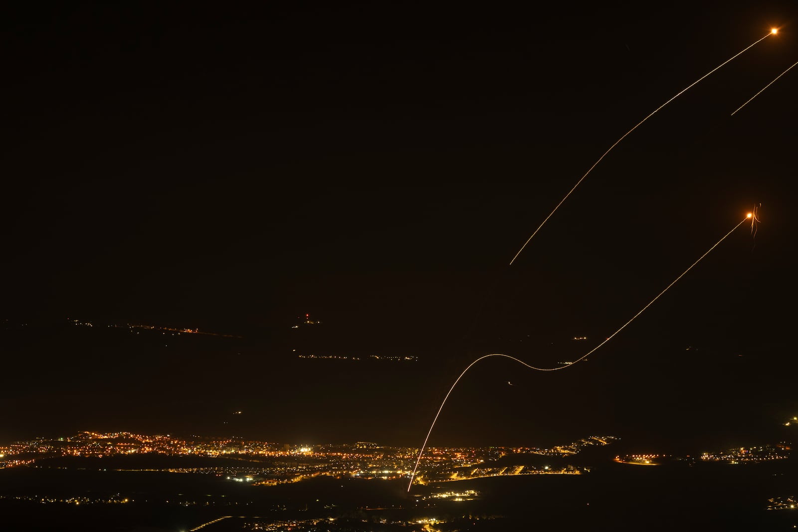 The Israeli Iron Dome air defense system fires to intercept rockets launched from Lebanon, near Kiryat Shmona, as seen from the Israeli-annexed Golan Heights, Saturday, Oct. 26, 2024. (AP Photo/Leo Correa)