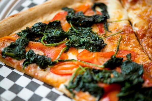 Junior's Pizza slice with spinach and red bell pepper toppings. Photo credit- Mia Yakel.