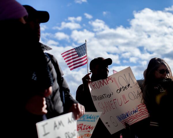 Demonstrators hold signs at Hartsfield-Jackson International Airport during a demonstration to denounce President Donald Trump's executive order that bars citizens of seven predominantly Muslim-majority countries from entering the U.S., Sunday, Jan. 29, 2017, in Atlanta. (AP Photo/Branden Camp)