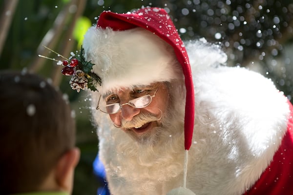 Santa Claus Keith Carson, of the Believe in Santa Foundation, visits children during a Christmas in July event at Palm Beach Children's Hospital on Friday, July 25, 2014 in West Palm Beach. Fake snow floated through the hospital courtyard and Santa Claus went room-to-room to deliver presents. (Madeline Gray / The Palm Beach Post)