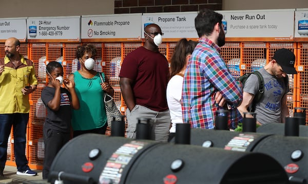 Customers wait in line to enter the Home Depot store at Midtown Place while the store limits the number of occupants to maintain six feet of space between shoppers and help prevent the spread of coronavirus on Sunday, March 29, 2020, in Atlanta. Curtis Compton ccompton@ajc.com